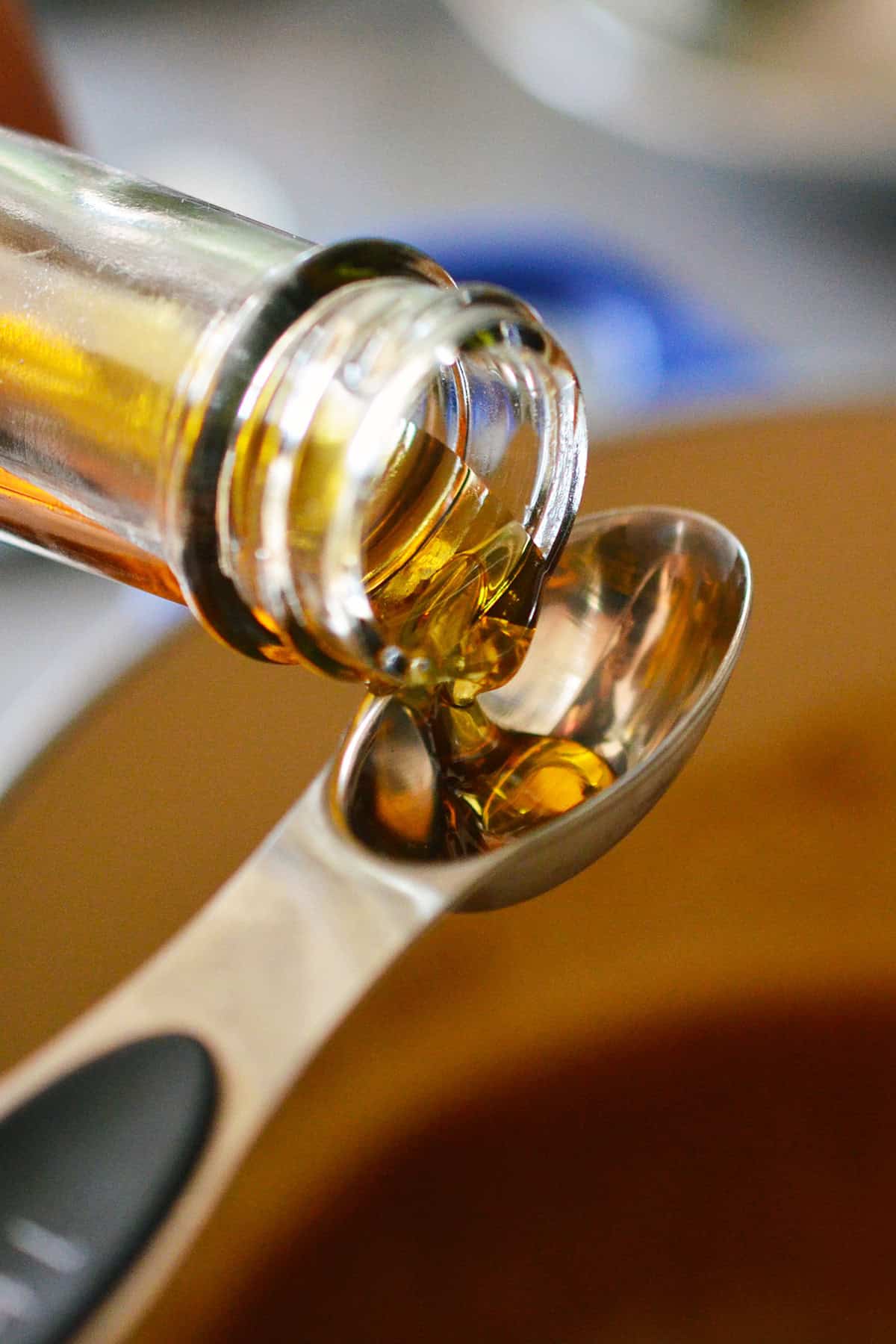 Pouring some toasted sesame oil into a measuring spoon.