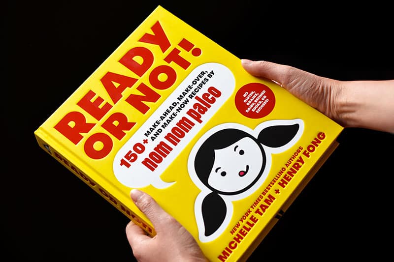 Someone holding a copy of Ready or Not! cookbook by Michelle Tam & Henry Fong.