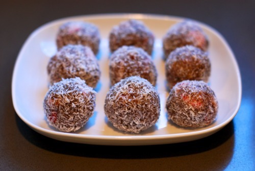 A front view of a square white plate topped with 9 strawberry energy bites