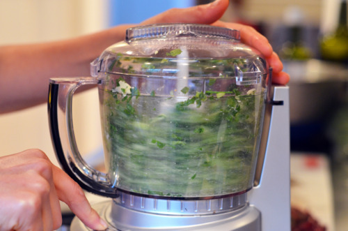 Someone pulsing the herb-stuff ingredients in a food processor.