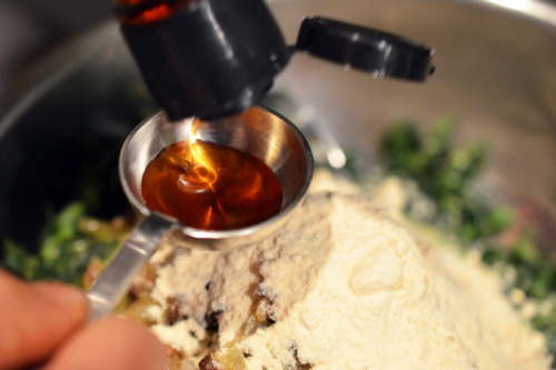 Someone measuring out fish sauce to be put in a bowl with the ingredients for the pork sliders.